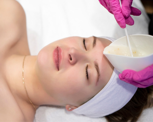 Woman laying down with eyes closed about to receive a facial treatment.