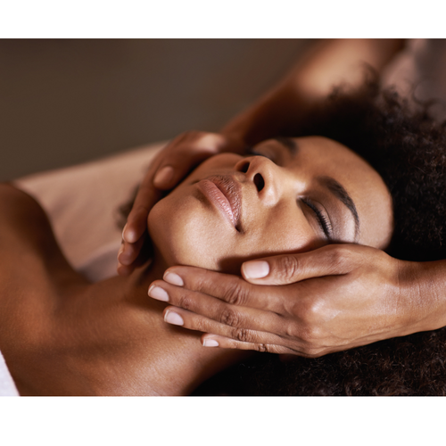 Esthetician adjusting woman's face during dermaplane treatment