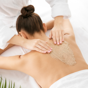 Woman receiving a back facial scrub.