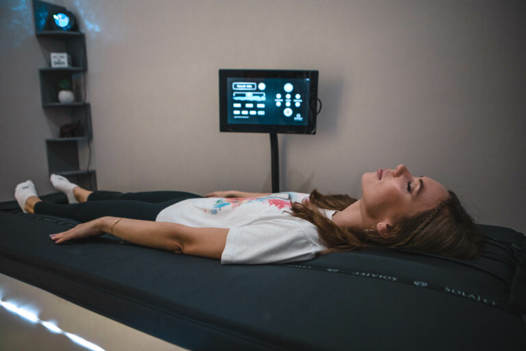 Close up of woman laying on Solajet massage bed and digital screen behind her.