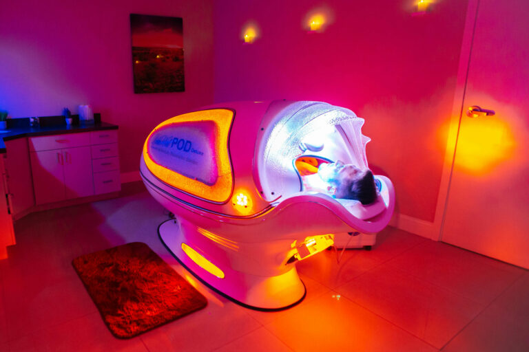 Man laying down in the infrared pod receiving treatment
