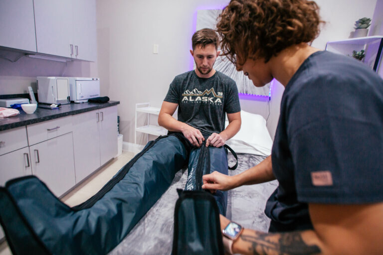 Wellness therapist closing pressotherapy device on a man's leg