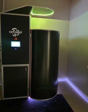 Empty full body cryotherapy chamber with yellow glowing light